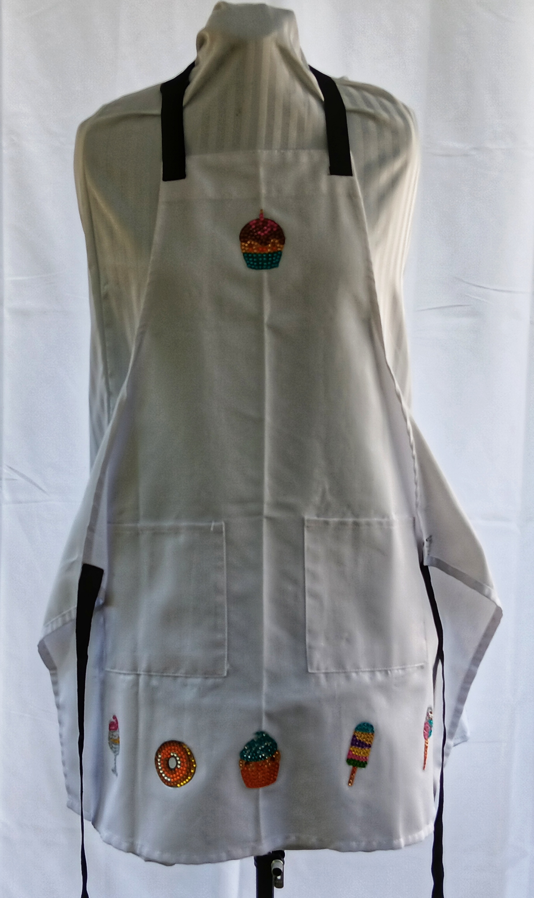 
White apron with pockets featuring cupcakes done in diamond art